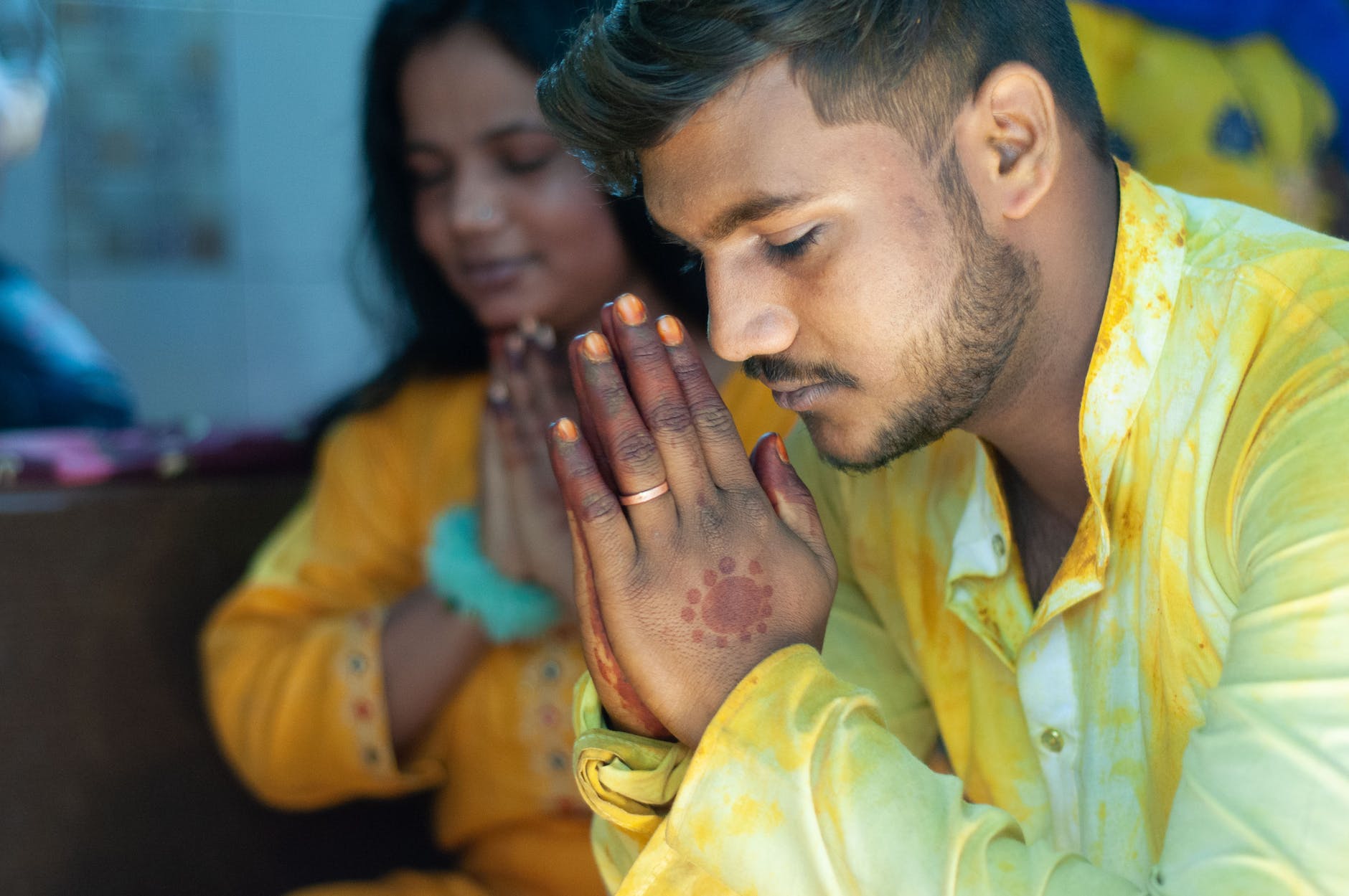 man praying with his eyes closed and hands together