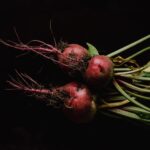 close up photo of beetroots on black background